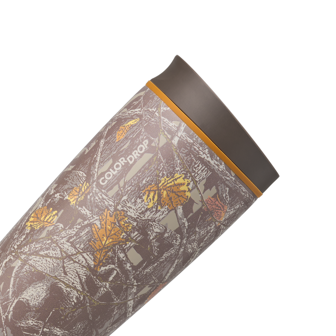 Owala SmoothSip Slider 20oz in Out of Sight, body close-up showing oak-leaf camouflage pattern with dark brown "COLOR DROP" print and orange accent ring at the lid base